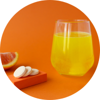 A glass of orange juice accompanied by a vitamin pill, providing a refreshing and nutritious combination.
